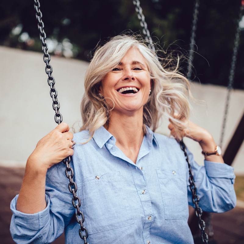 senior woman swinging while laughing